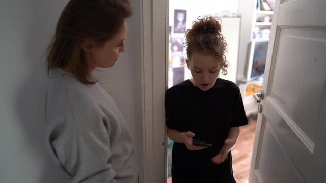 Mother knocks on the door of the daughters room. Internet addiction. Quarrel between mother and teenage daughter. Problems of the relationship between parents and children