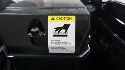 Machine cover with hot surface safety signage. Caution of hazard or danger.