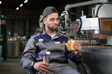 A young factory worker is enjoying lunch. Lunch break at work