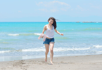 ビーチを走る若い女性