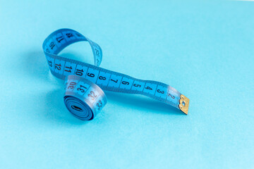 Blue centimeter ribbon on a blue background.