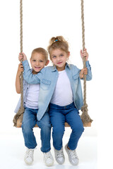 Boy and girl sitting on rope swing