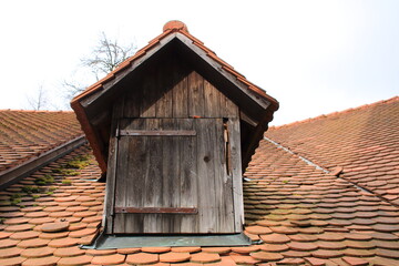 Fototapeta na wymiar Alte Dachgaube auf einem Dach mit einem Fenster aus Holz