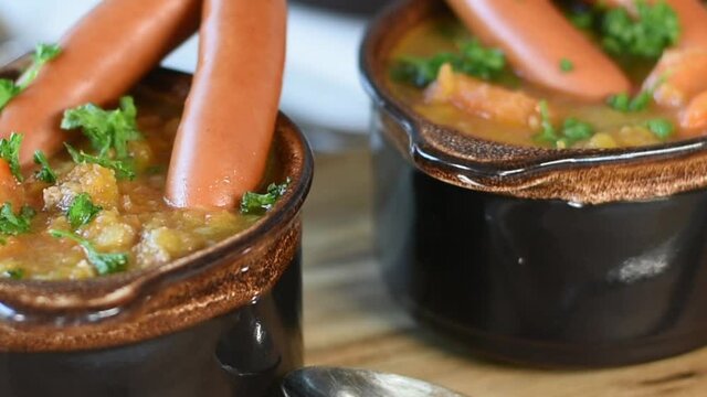 vegetable stew with sausages in rustic brown bowls with zoom effect