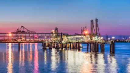 Fototapeten Industrial pier near petrochemical production plant during a colorful sunset, Port of Antwerp, Belgium © tonyv3112