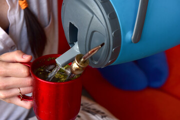 Woman pouring mug of cold drink. Typical of south america tereré.