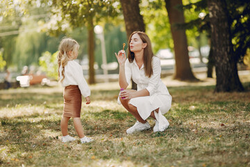 Mother with little daughter playing in a summer park