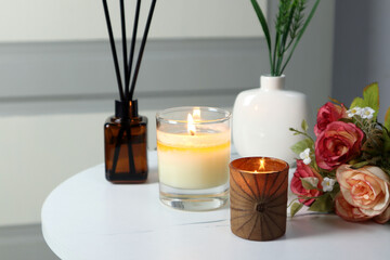 luxury lighting aromatic scented candle is on the mable table with reed diffuser to creat romantic and relax ambient in the grey bedroom with background of grey wooden door on valentine day