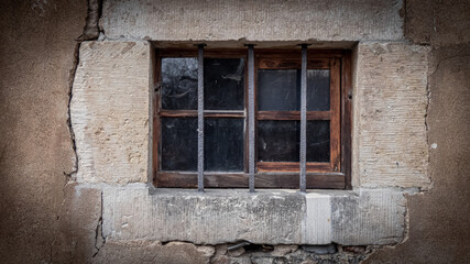 Fototapeta na wymiar Altes Holzfenster mit Gitterstäben in einem Gemäuer