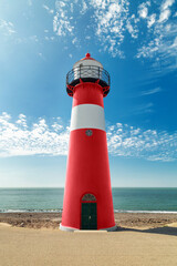 Red and white lighthouse on the sea coast