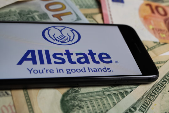 Viersen, Germany - March 1. 2021: Closeup of smartphone with logo lettering of allstate insurance company on paper money currency