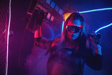 Young girl is dancing in the neon lights on the dance floor.