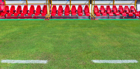 Front view of red bench or seat or chair of staff coach or substitution player in the stadium of football or soccer.