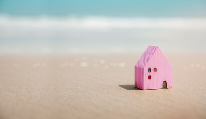 Beach House Concept. Mini Colorful Wooden House on the Sand Beach. Destination for Vacation or...