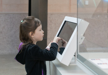girl using display at the museum. Learning and education concept.