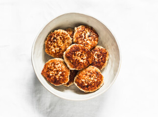 Chicken burgers in a bowl on a light background, top view
