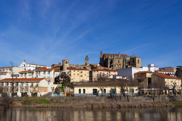 Plasencia city skyline with the Jerte river in the foreground and the cathedral and other historic buildings in the background