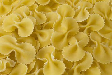 Texture with raw farfalle pasta. Uncooked ingredient of Italian food isolated on white background