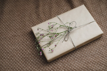  a gift box in craft paper decorated with a flower