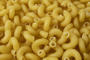 Texture with raw cavatappi or cellentani pasta. Mac and cheese noodles.