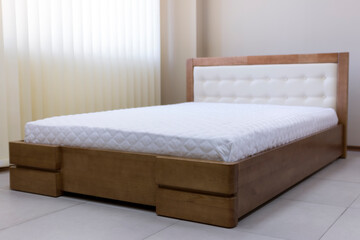 lacquered wooden double bed with a soft headboard