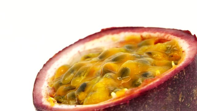 4K cross-section of a puple passion fruit Macro shot of sliced fresh exotic passion fruit fruit rotating  isolated on white background
