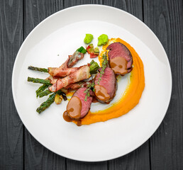 Grilled veal tenderloin with salad, with asparagus and bacon