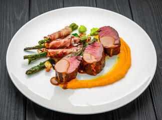 Grilled veal tenderloin with salad, with asparagus and bacon