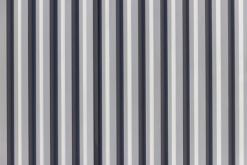 The fence is made of corrugated board. Alternating vertical black and white stripes.
