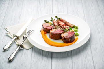 Grilled veal tenderloin with salad, with asparagus and bacon