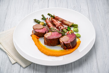 Grilled veal tenderloin with salad, with asparagus and bacon