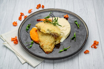 Top view of fish fillet in batter with mashed potato on wooden table