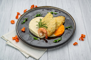 Top view of fish fillet in batter with mashed potato on wooden table