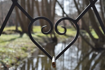 Vintage heart in the fence of the bridge with a lock.
