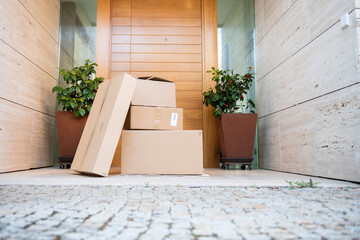 Several packages on the floor in front of the door.Parcels on rug near door.