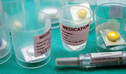 Diverse medication in glasses monodose along with heparin injectors in hospital, conceptual image