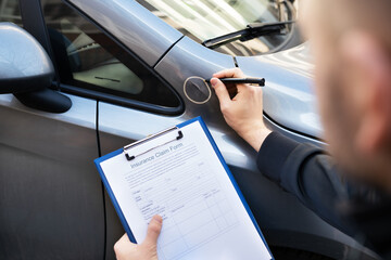 Insurance Agent Or Adjuster Inspecting Car