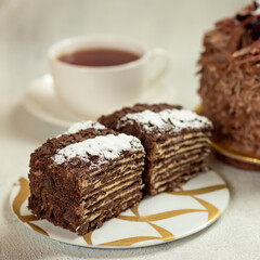 Tasty Chocolate cake slice with cup of tea isolated on white