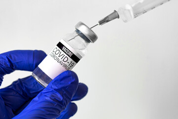 Healthcare and cure concept backgrond, hand holds vaccine vial and medical syringe with needle inside the vial