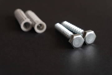 screws and wall plugs on a black background. Hardware concept