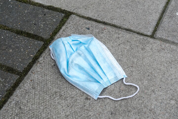 Used surgical face mask, discarded face mask on street