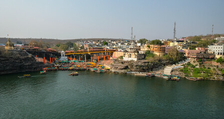 Fototapeta na wymiar Omkareshwar, India - March 2021: Views of Omkareshwar from Mandhata Island located on the Narmada River on March 20, 2021 in Madhya Pradesh, India.