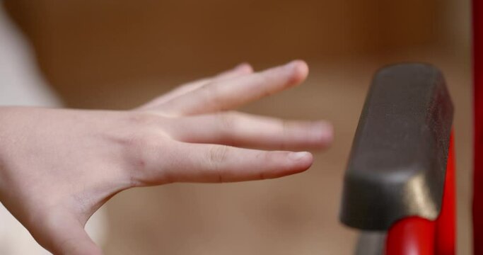 The hand of a disabled boy tries to reach a wheelchair standing by the bed. The concept of paralysis in children who face daily mobility problems.