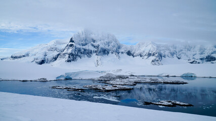 Snow covered Mountains and Icebergs in the Antarctic Peninsula on Antarctica.