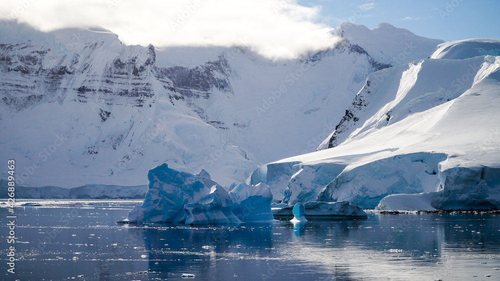 Wall mural snow covered mountains and icebergs in the antarctic peninsula on antarctica.