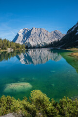 Zugspitze mountain reflecting in turquoise water of lake Seebensee, idyllic landscape Ehrwald tirol
