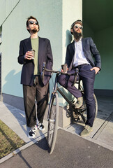 Obraz premium Two friends enjoying coffee together outside with with bicycle .