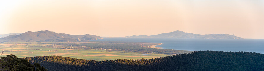 Italy, Tuscany, Tirli, panoramic view at the sunset of the Meremmana plain, the coastline up to the Uccellina mountains and the Monte Argentario, in the background the island of Giannutri.