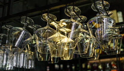 Rows of empty wine glasses on the showcase in the restaurant or bar. Table setting, close up. Glasses for alcohol.