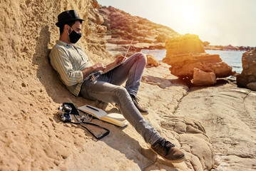 A young traveler uses his laptop to telecommute outdoors